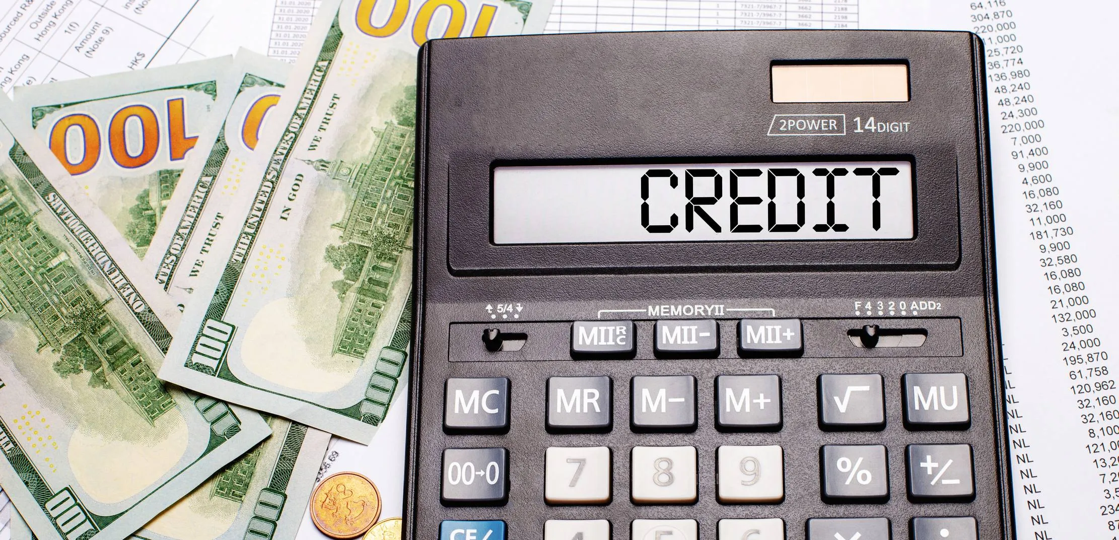 Une calculatrice avec le mot credit près de billets et de chiffres de registre ; les devises et montants visibles sont sans lien avec les UM fictives de cet article.