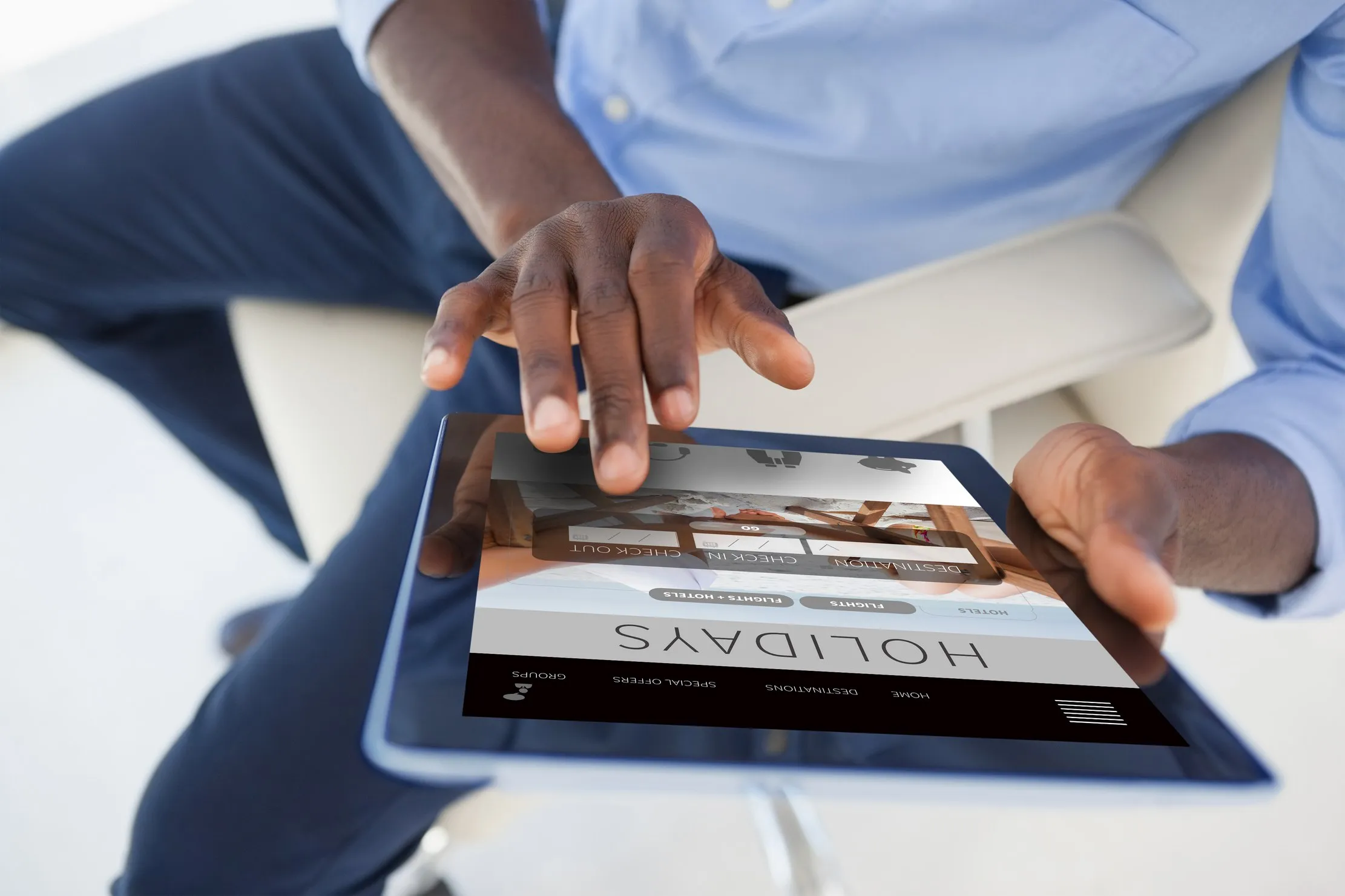 article-figure-landscape A person holding a tablet, seen from above, while seated in a chair