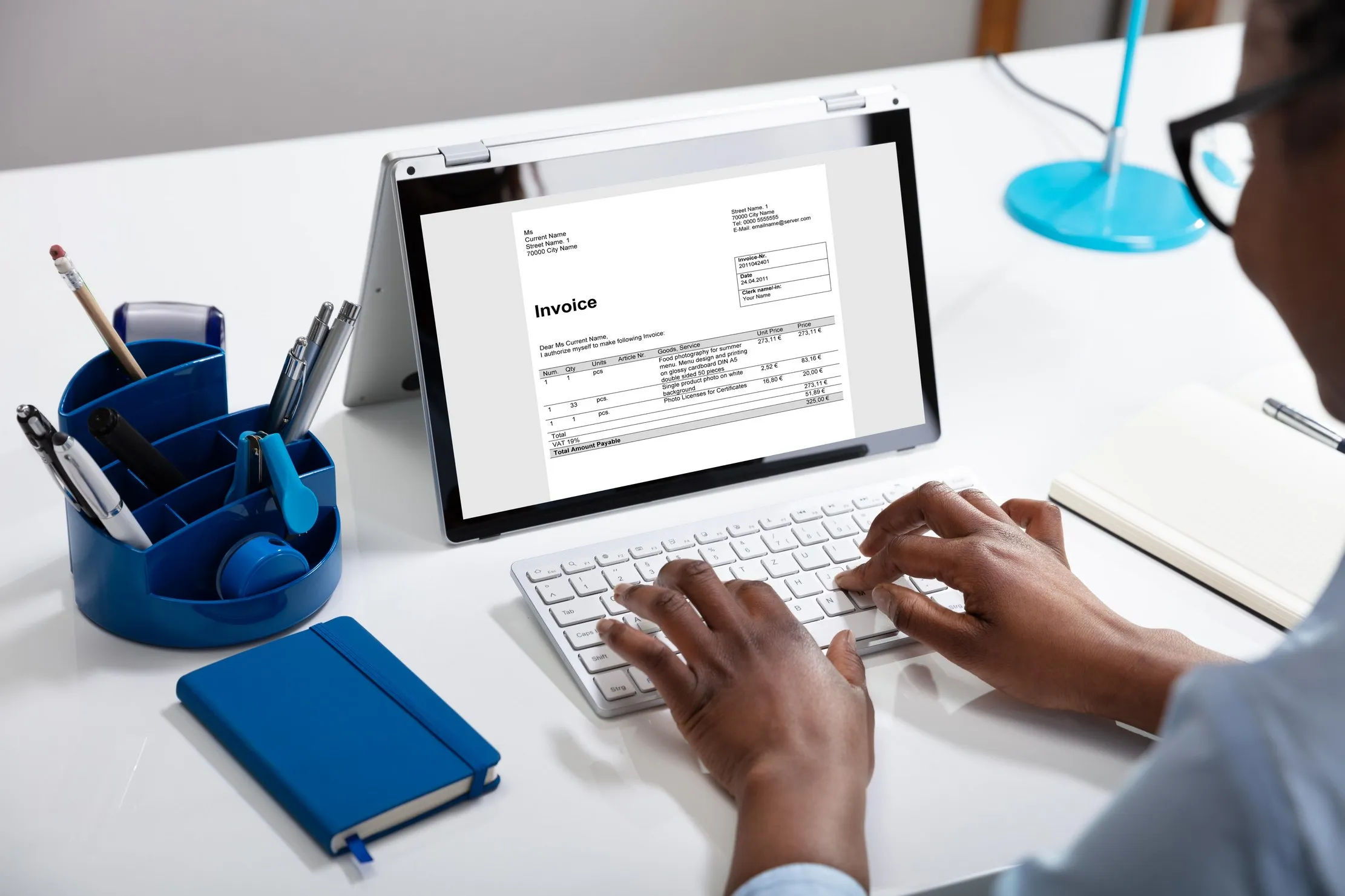 Businesswoman using a laptop to prepare an invoice, representing the request and approval steps in an ERP workflow