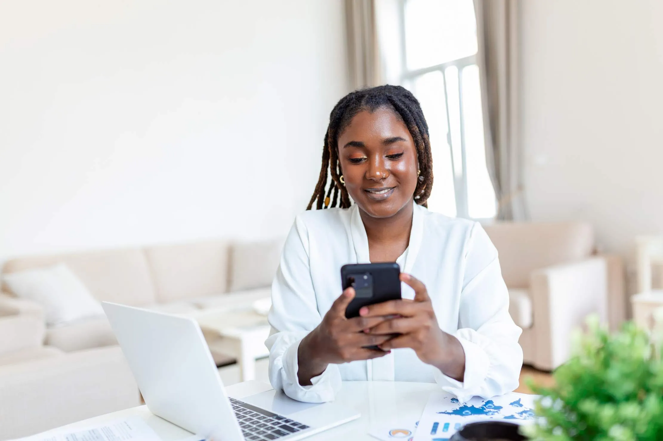 African businesswoman using smartphone in office — mobile-first business apps for East African SMEs